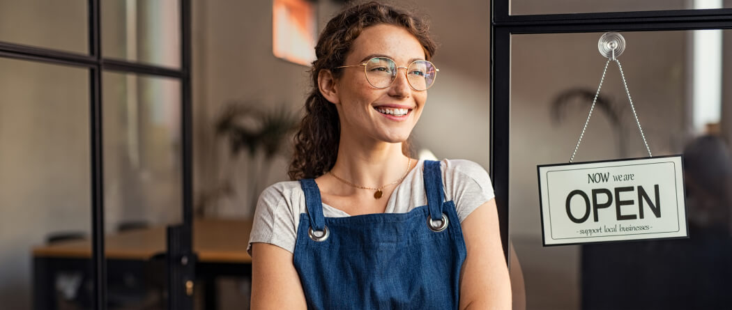 Young woman in front of an "OPEN" sign