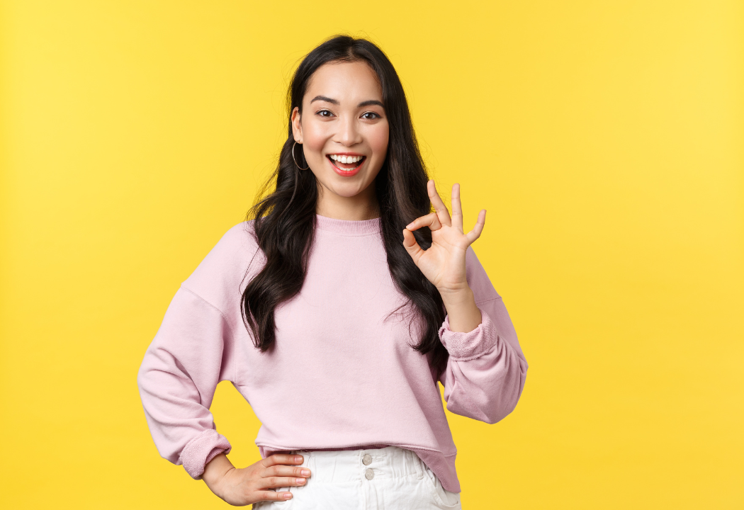 woman smiling with an okay hand sign
