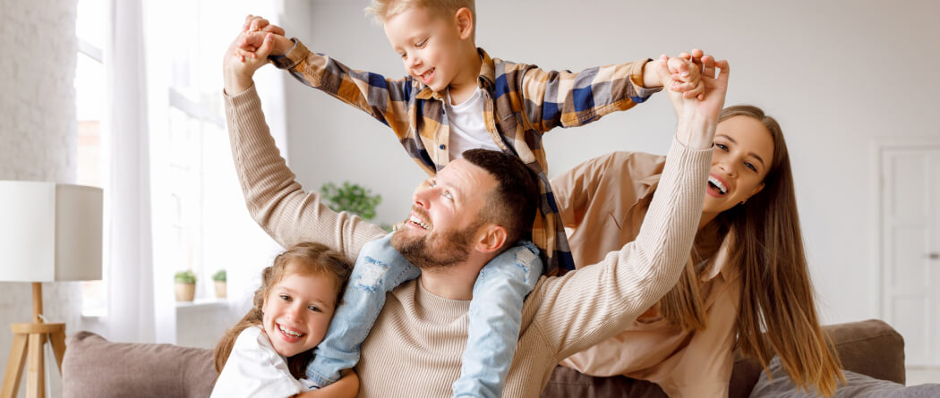 Young family playing on a couch