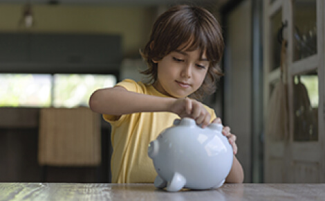 Young kid opening a piggy bank