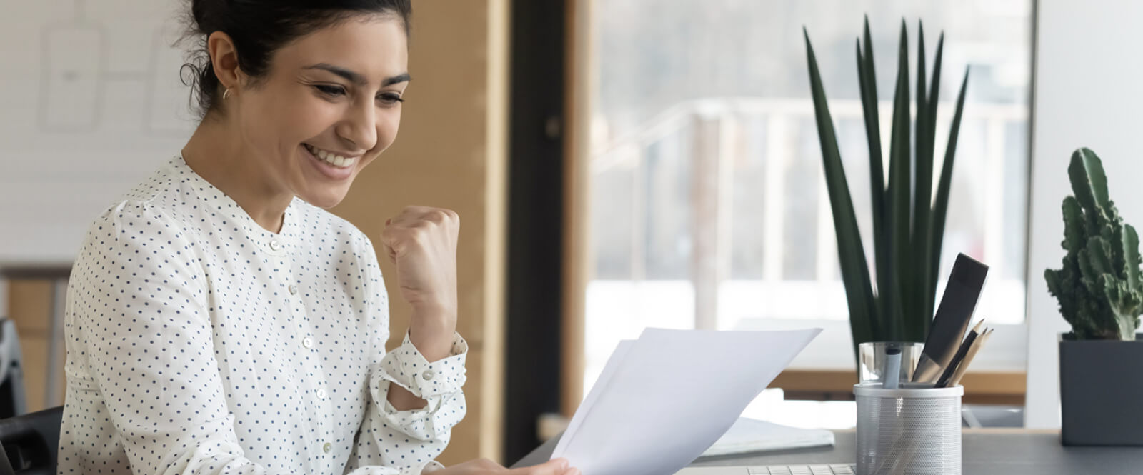 Young woman smiling and looking at a stack of papers